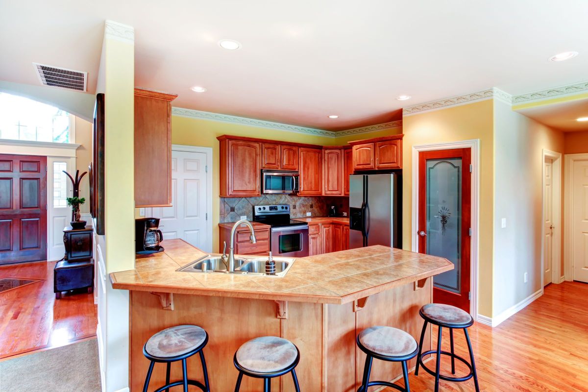Red Wooden Kitchen Cabinets and Bar Stool Seating