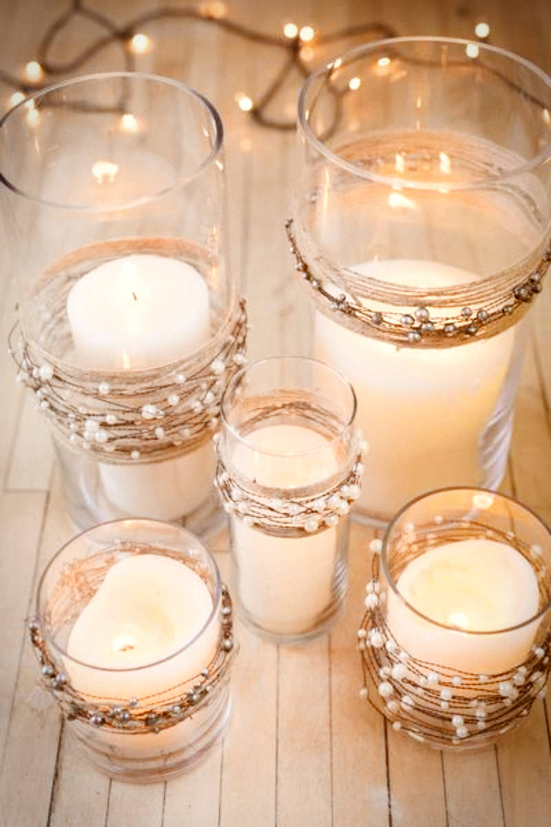 A glass candle holder with mercury garlands.